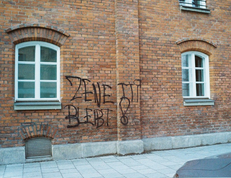 Ein analoges Farbfoto von der Ziegelwand des Volkstheaters mit dem Grafitti 