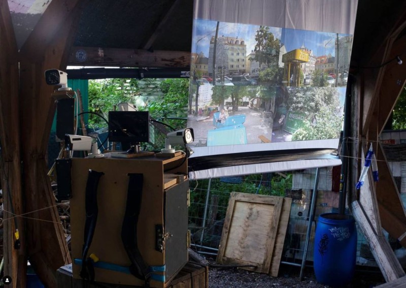 Zu sehen ist der Überwachungskamerarucksack und ein Beamer, der ein Video zeigt.